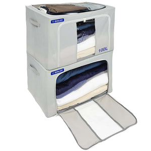 Two stacked BOXJOY 100L grey fabric storage boxes with top and front zippered openings filled with folded clothes and bedding.