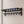 Black BOXJOY wall-mounted bathroom shelfs with lower hanging hooks installed on a tiled wall.