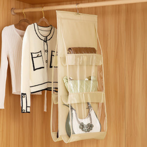 Hanging handbag organizer storing multiple purses beside clothes in a wardrobe