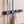 Grey BOXJOY wall-mounted organizer holding a squeegee, a broom, and a hanging towel on a tiled wall.