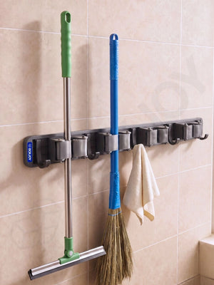 Grey BOXJOY wall-mounted organizer holding a squeegee, a broom, and a hanging towel on a tiled wall.