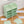 Durable material of the green wardrobe with 12 shelfs showing a sturdy metal frame and plastic doors.