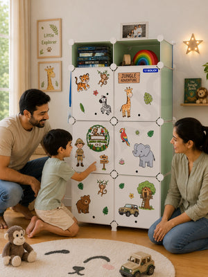 Smiling family watching a boy point at jungle stickers decorating his green wardrobe with 7 shelfs.